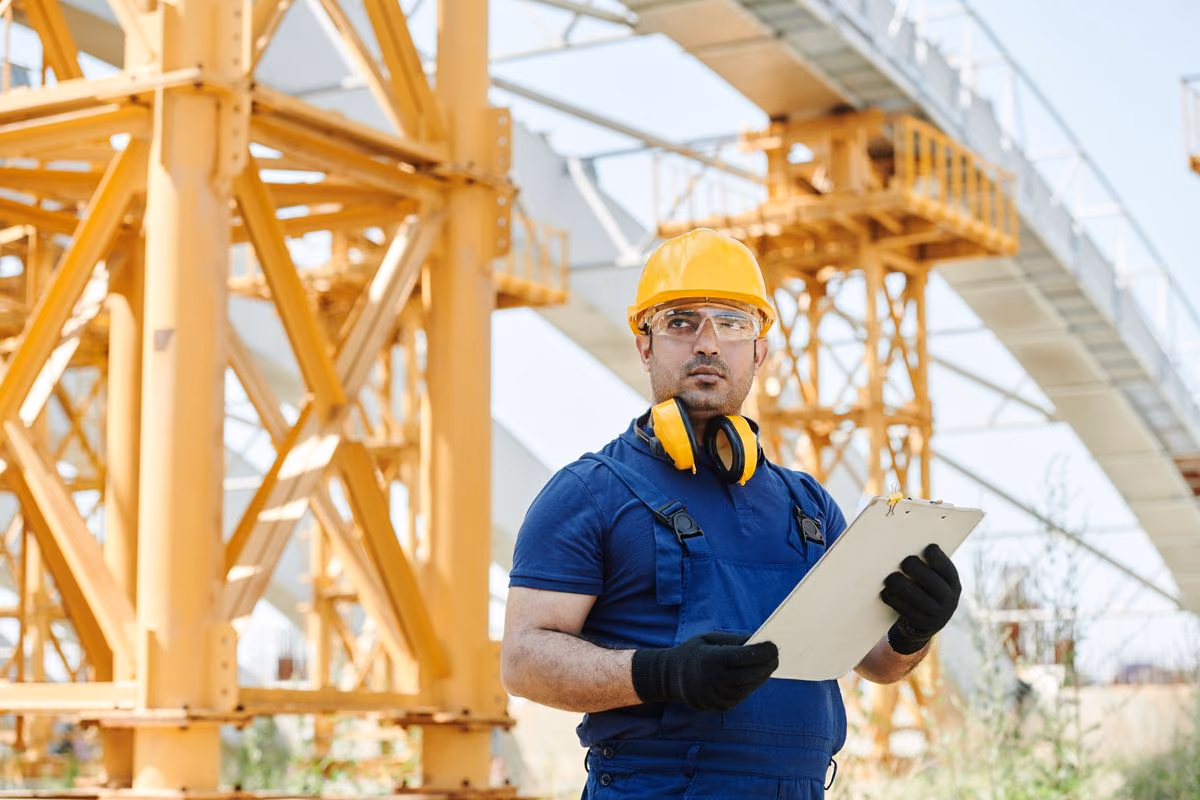 Professionnel en tenue de sécurité, un carnet à la main, lors d’une inspection sur un site technique. Photo d’illustration.